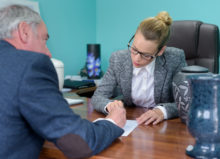 funeral director completing paperwork with senior man