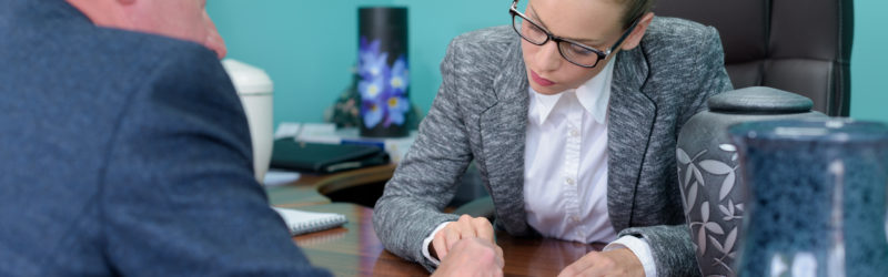 funeral director completing paperwork with senior man